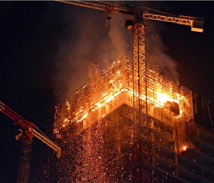 a tall commercial building being built on fire